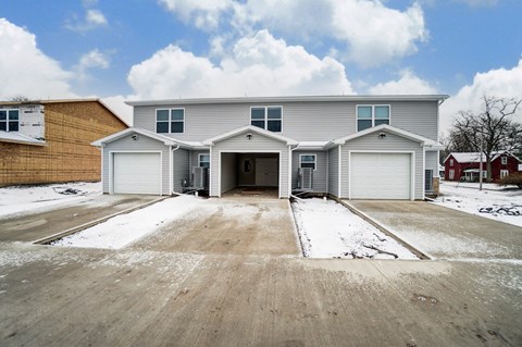 A large, two-story house with a garage and driveway.