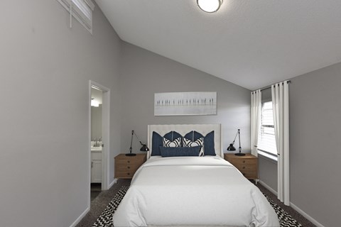 a bedroom with a large white bed and a window