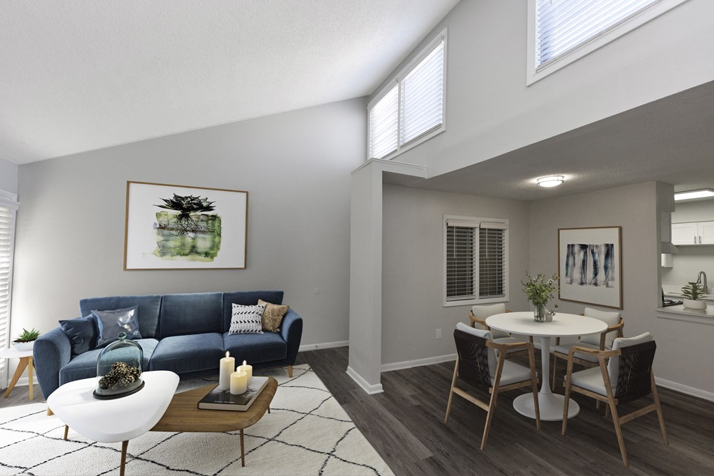a living room with a blue couch and a dining room table