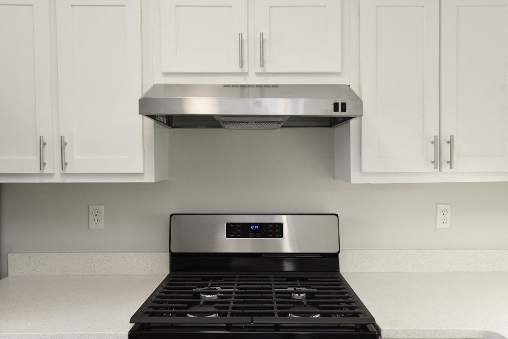 a kitchen with white cabinets and a black stove