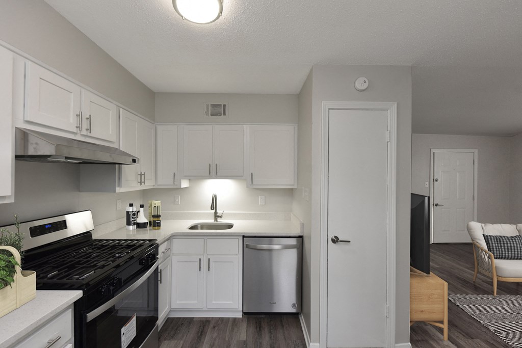 an empty kitchen with white cabinets and a black stove
