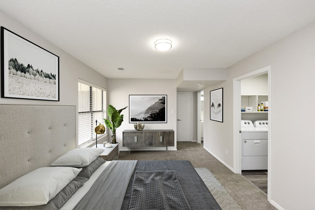 a bedroom with a bed and a dresser and a bathroom