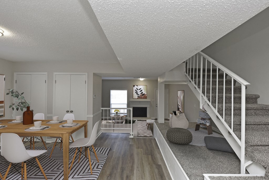 the living room and dining area of a house with a staircase