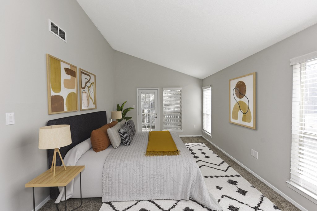 a bedroom with a large bed with a yellow blanket and pillows