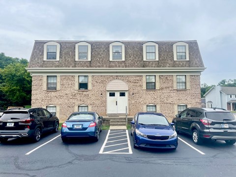 A parking lot with cars and a building in the background.