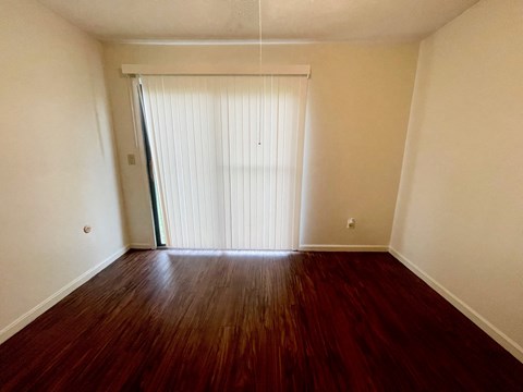 A room with a wooden floor and a sliding door.