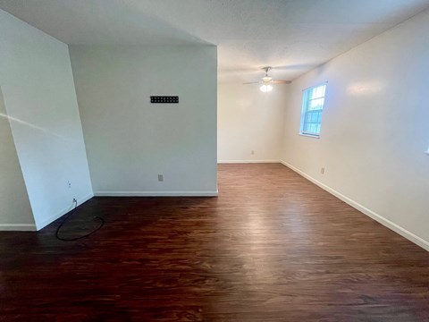 A room with wooden flooring and a window.