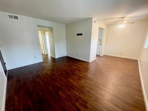 A room with wooden flooring and white walls.