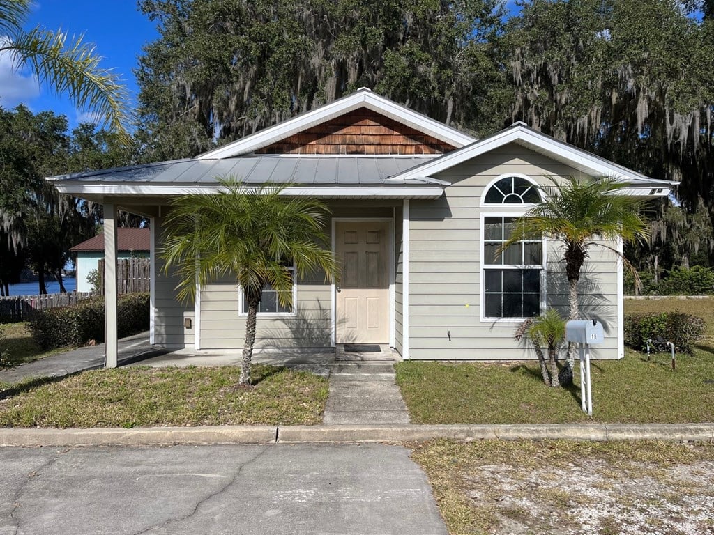 a small white house with palm trees in front of it
