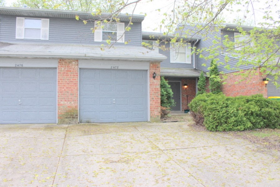 the front of a house with two garage doors