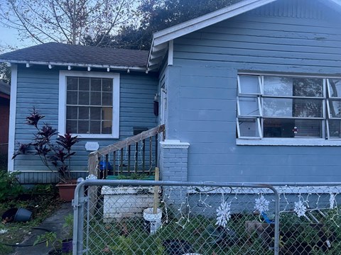 a blue house with a fence in front of it