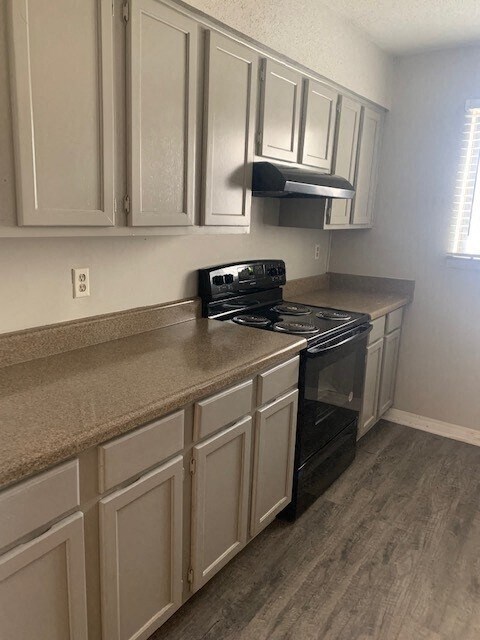 a kitchen with white cabinets and a black stove