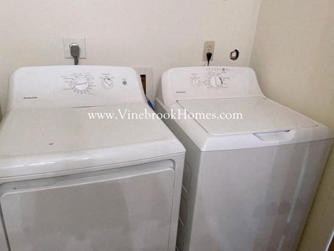 two washers and a dryer in a kitchen area of a home