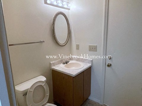 a small bathroom with a toilet and a sink and a mirror