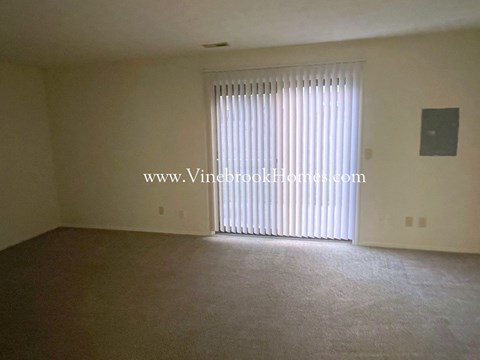 an empty living room with a sliding glass door