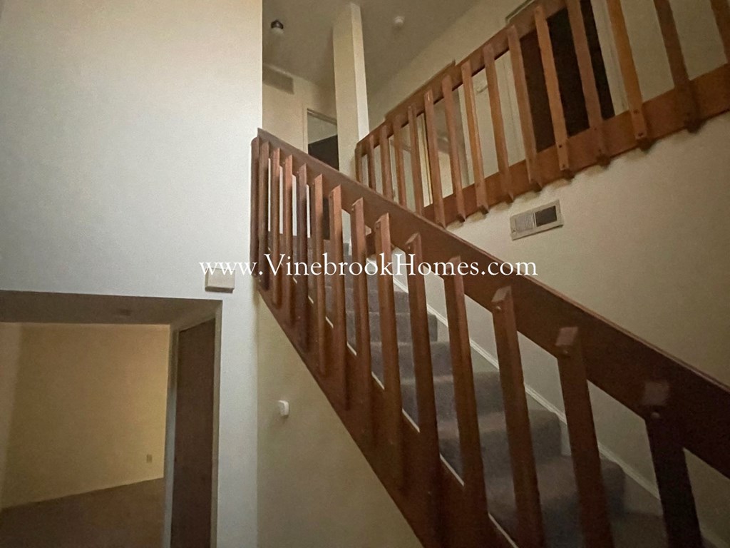 the upstairs of the house has a staircase and a door