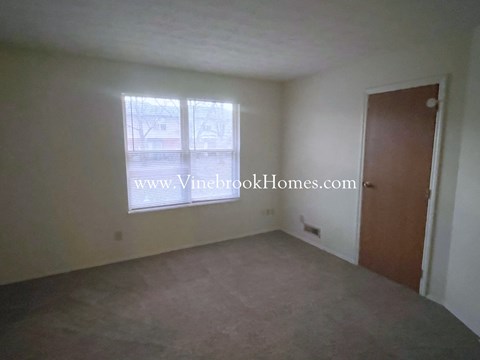 an empty living room with a window and a door