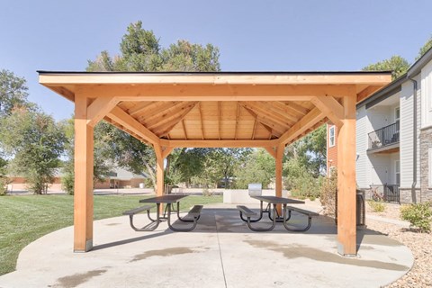 a picnic area with a pavilion with benches and tables