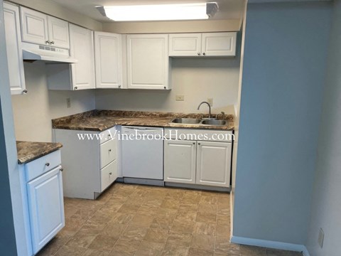 a kitchen with white cabinets and granite counter tops