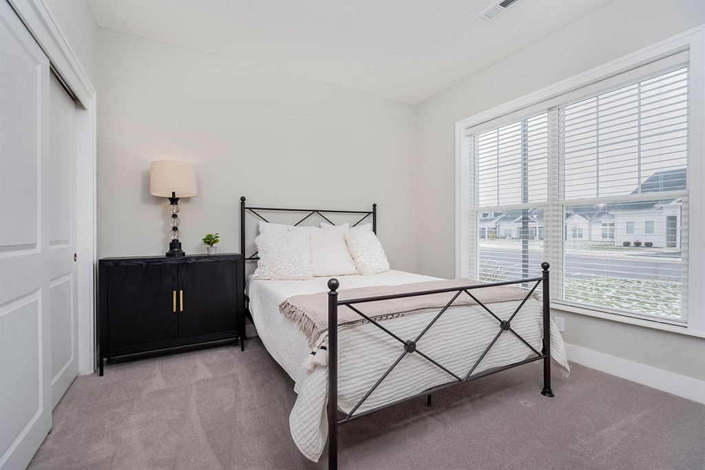 a bedroom with a bed and a large window