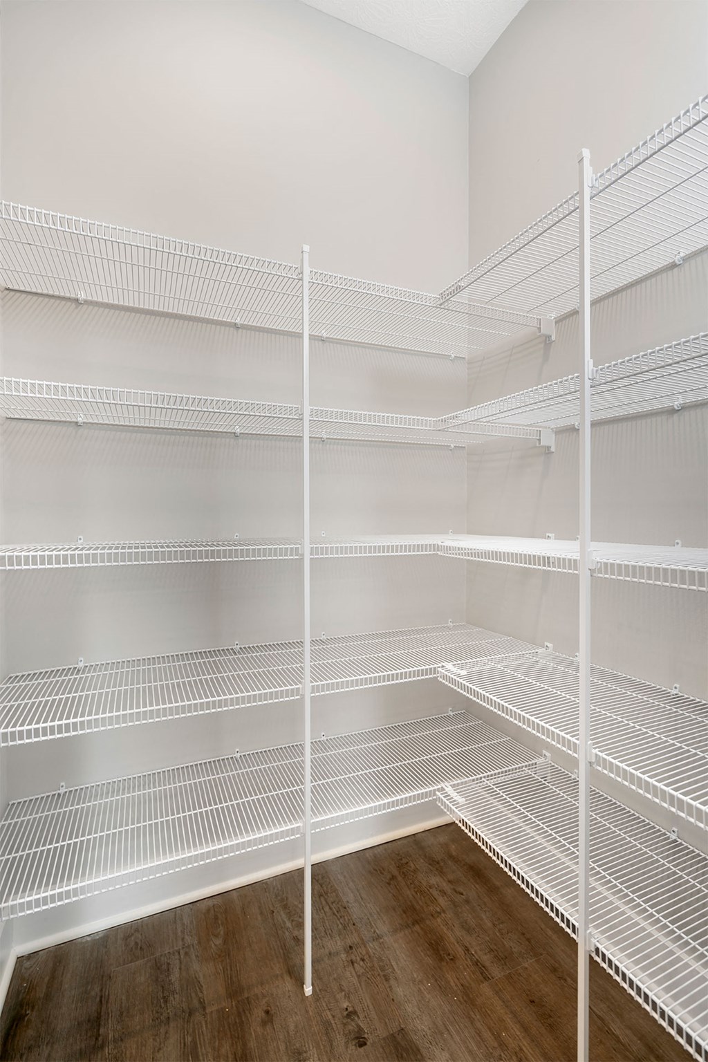 a room with white shelves and a wood floor