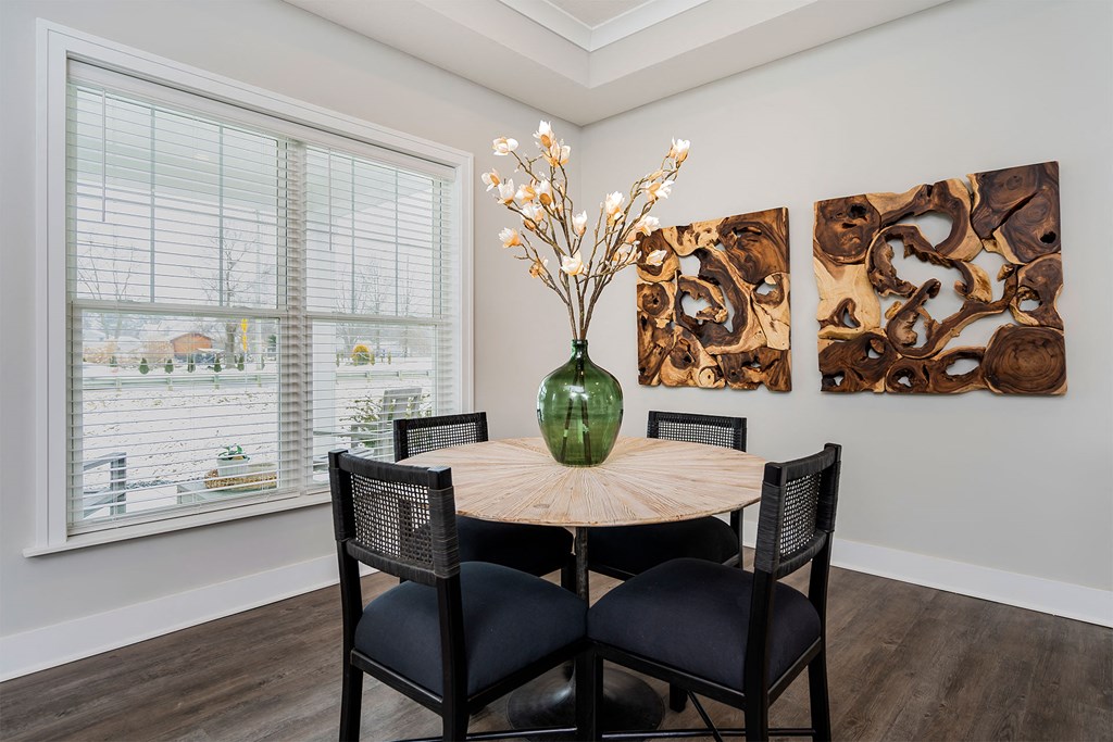a dining room with a table and chairs and a large window