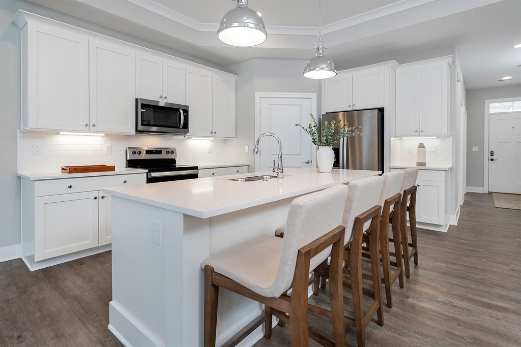 a large kitchen with white cabinets and a white counter top