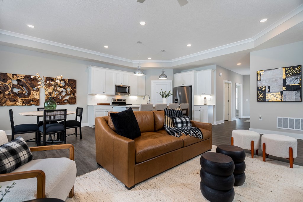 a living room with a leather couch and a kitchen