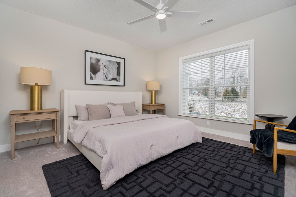 a bedroom with a bed and a large window