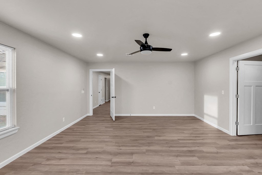 a living room with white walls and a ceiling fan
