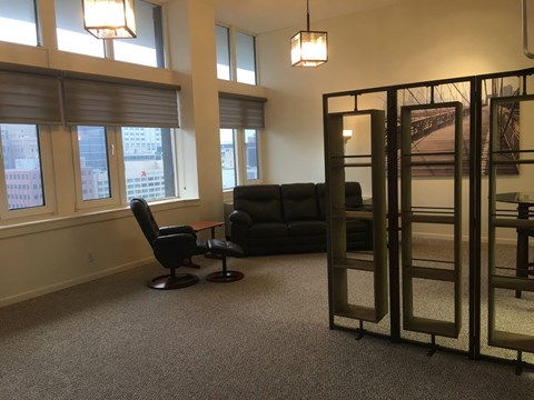 a living room with a couch and a chair and some windows