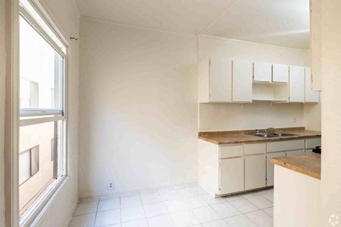A kitchen with white cabinets and a wooden countertop.