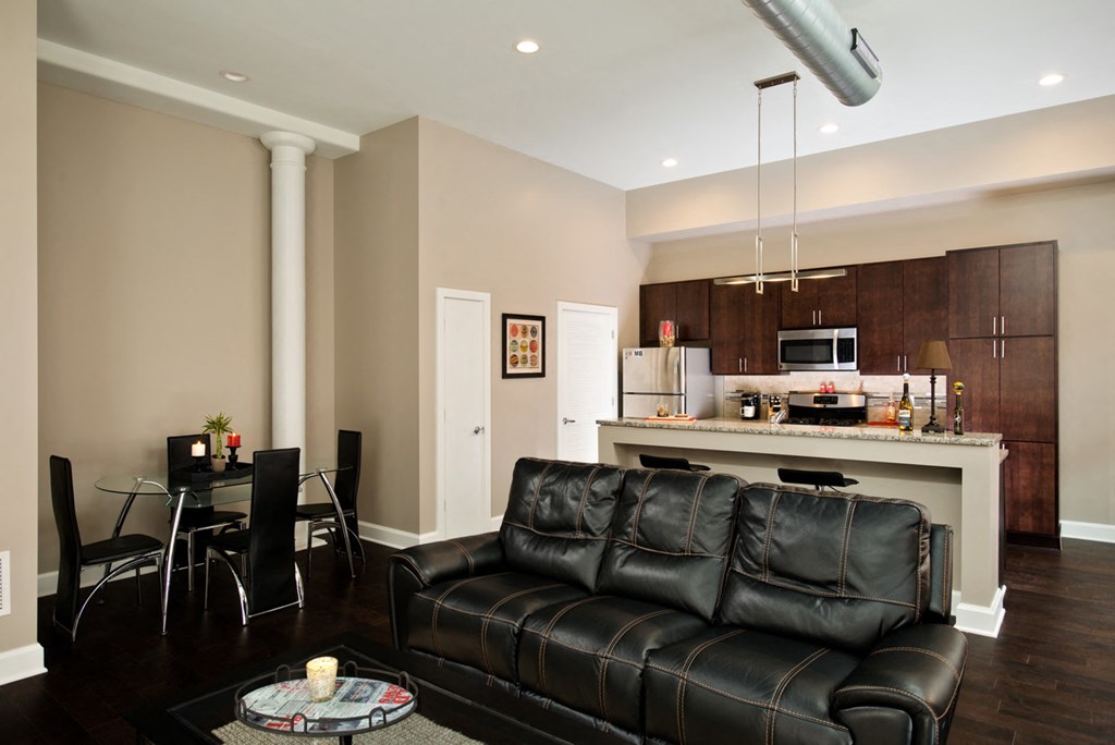 a living room with a leather couch and a table with chairs