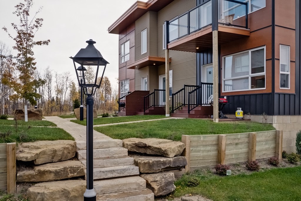 a home with stone steps and a lamp post in front of it