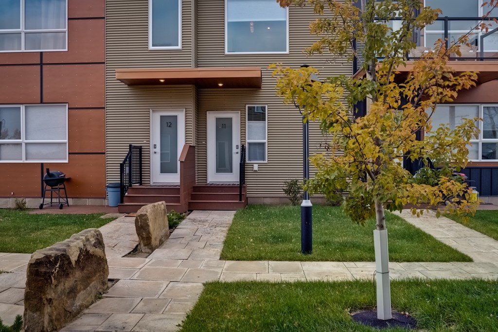 the front of a house with a sidewalk and grass