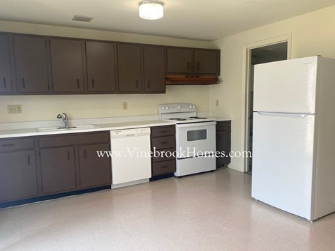 A kitchen with a white fridge and a white stove.