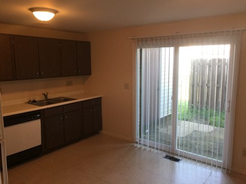A kitchen with brown cabinets and a white dishwasher.