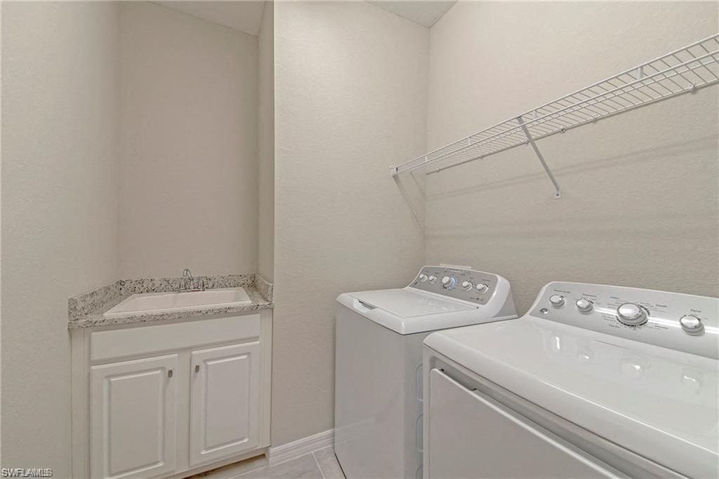 a laundry room with a washer and dryer and a sink