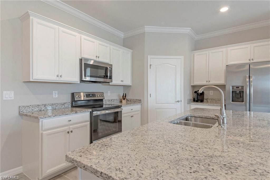 a kitchen with white cabinets and granite counter tops
