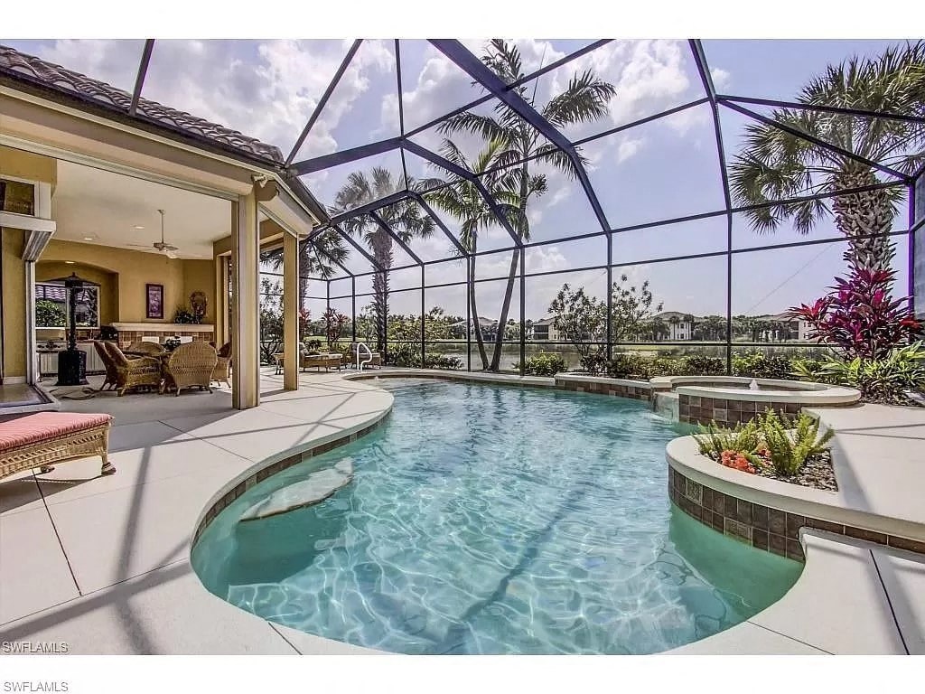 a pool is in the middle of a house with glass walls