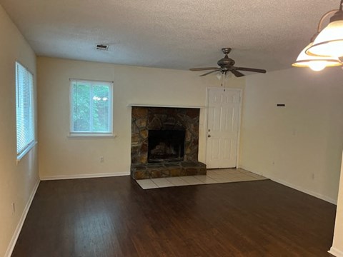 a living room with a fireplace and a ceiling fan