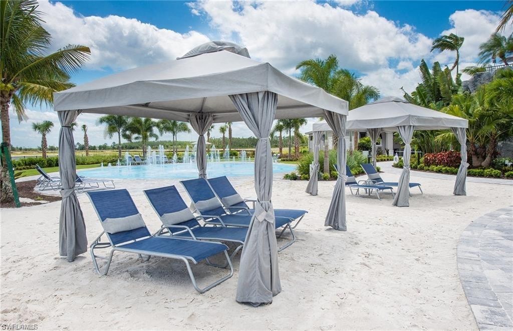 a group of beach chairs and umbrellas next to a pool