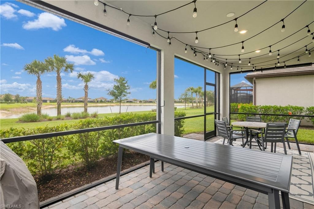 a patio with a table and chairs and a view of a lake