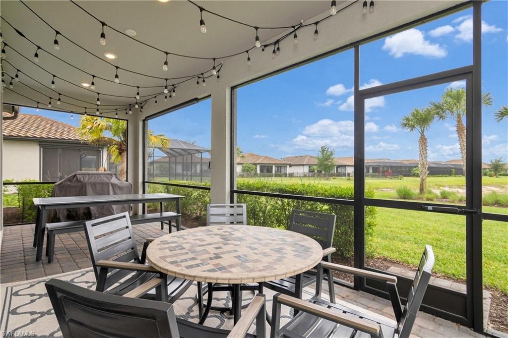 a patio with a table and chairs and large windows