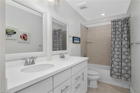 a bathroom with two sinks and a shower and a toilet