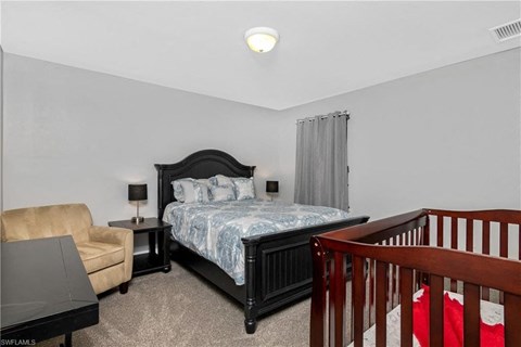 a bedroom with a bed and a crib and a couch