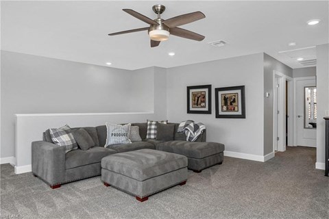 a living room with a couch and a ceiling fan