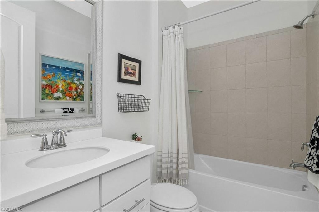 a white bathroom with a shower and a sink
