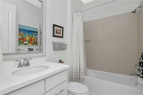 a white bathroom with a shower and a sink