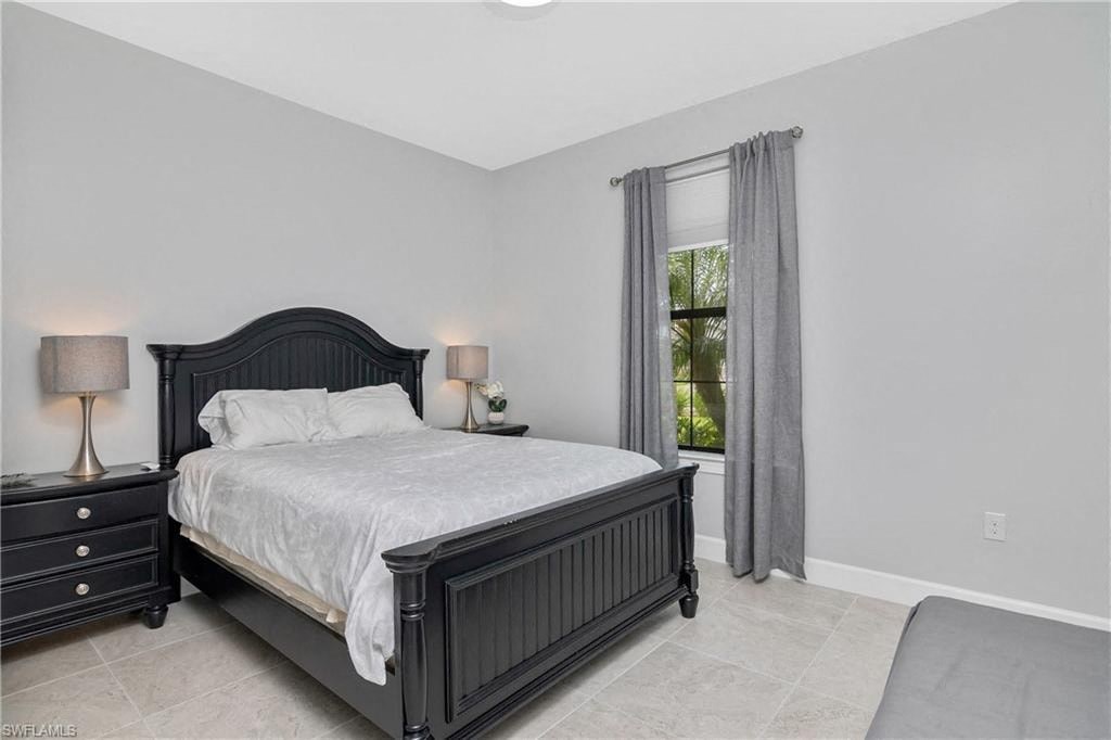 the master bedroom has a large bed and a window